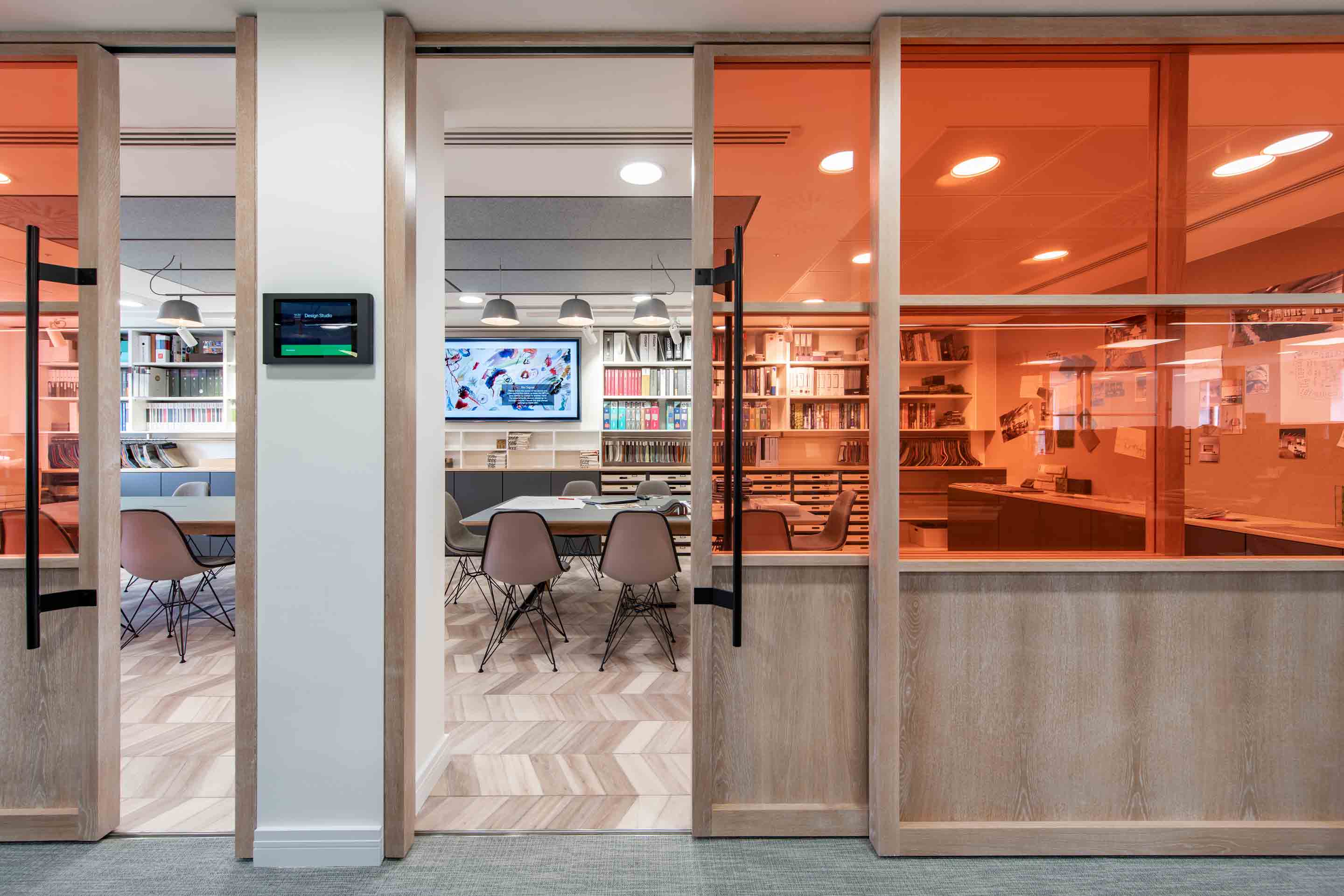 large meeting and design space with adaptable furniture and orange glass doors