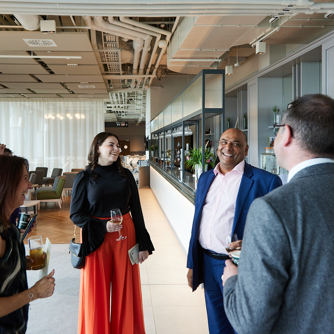 Several people gathered in a circle, actively discussing and sharing ideas in a friendly work atmosphere