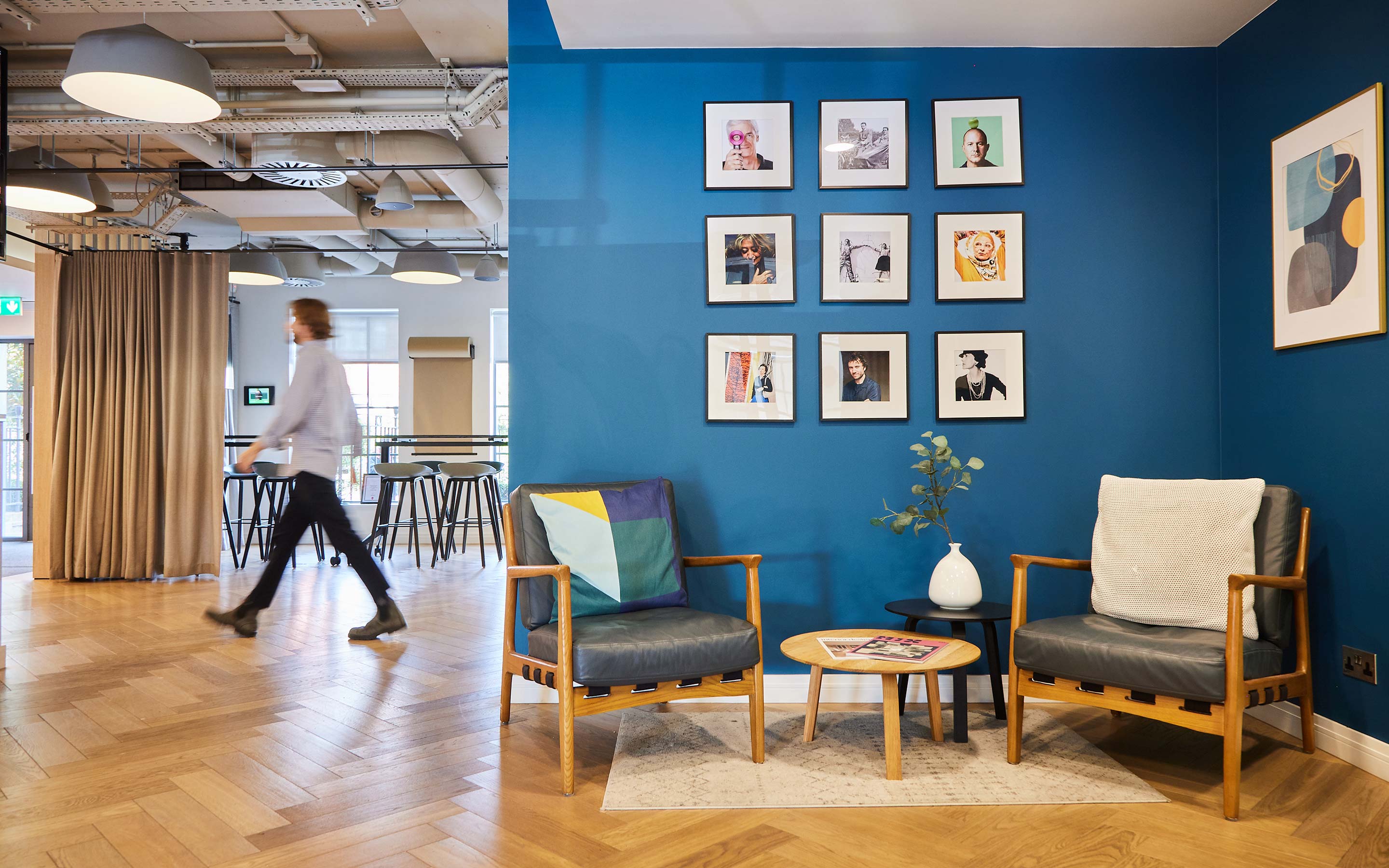 An office interior with blue-painted walls and warm wooden floors, designed for comfort and productivity