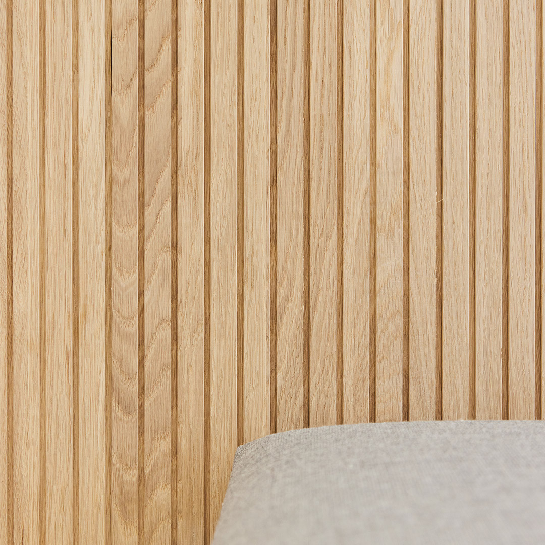 Detail shot of pale oak timber joinery and the corner of a neutral-coloured chair