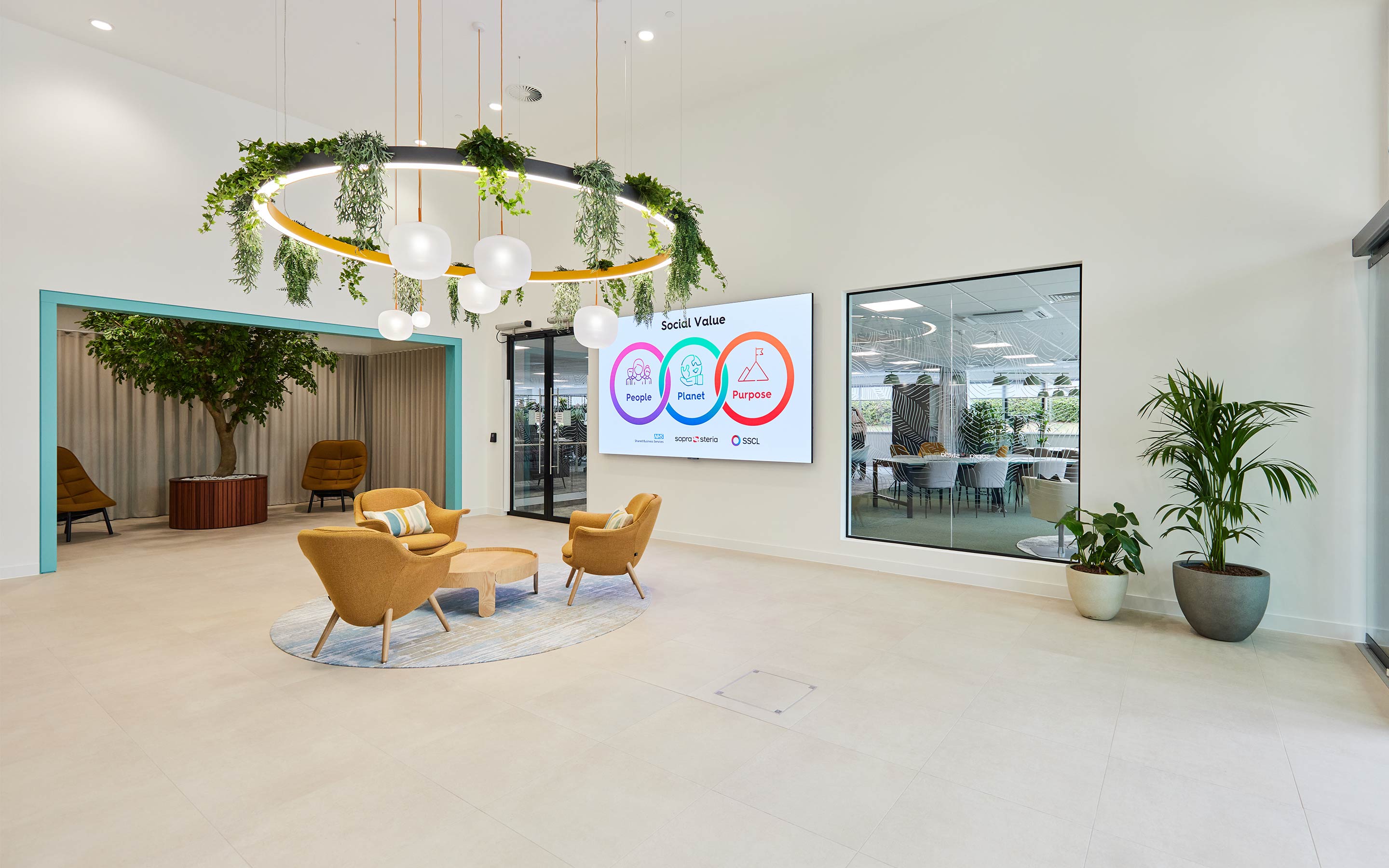 Large office reception area with pendant lighting and indoor planting