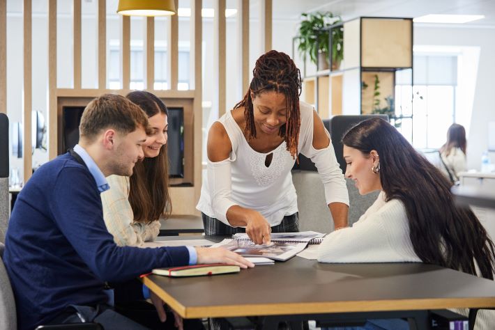 Three professionals collaborating over documents at a modern office table.