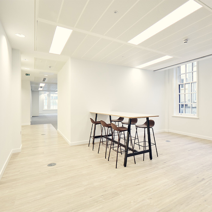 Modern office interior with a table, chairs, and bright lighting.